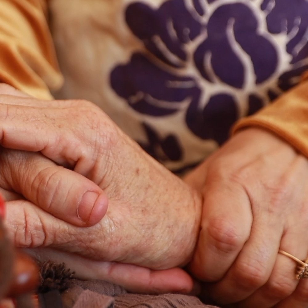The practitioner holds the patient hand over the warm pack.