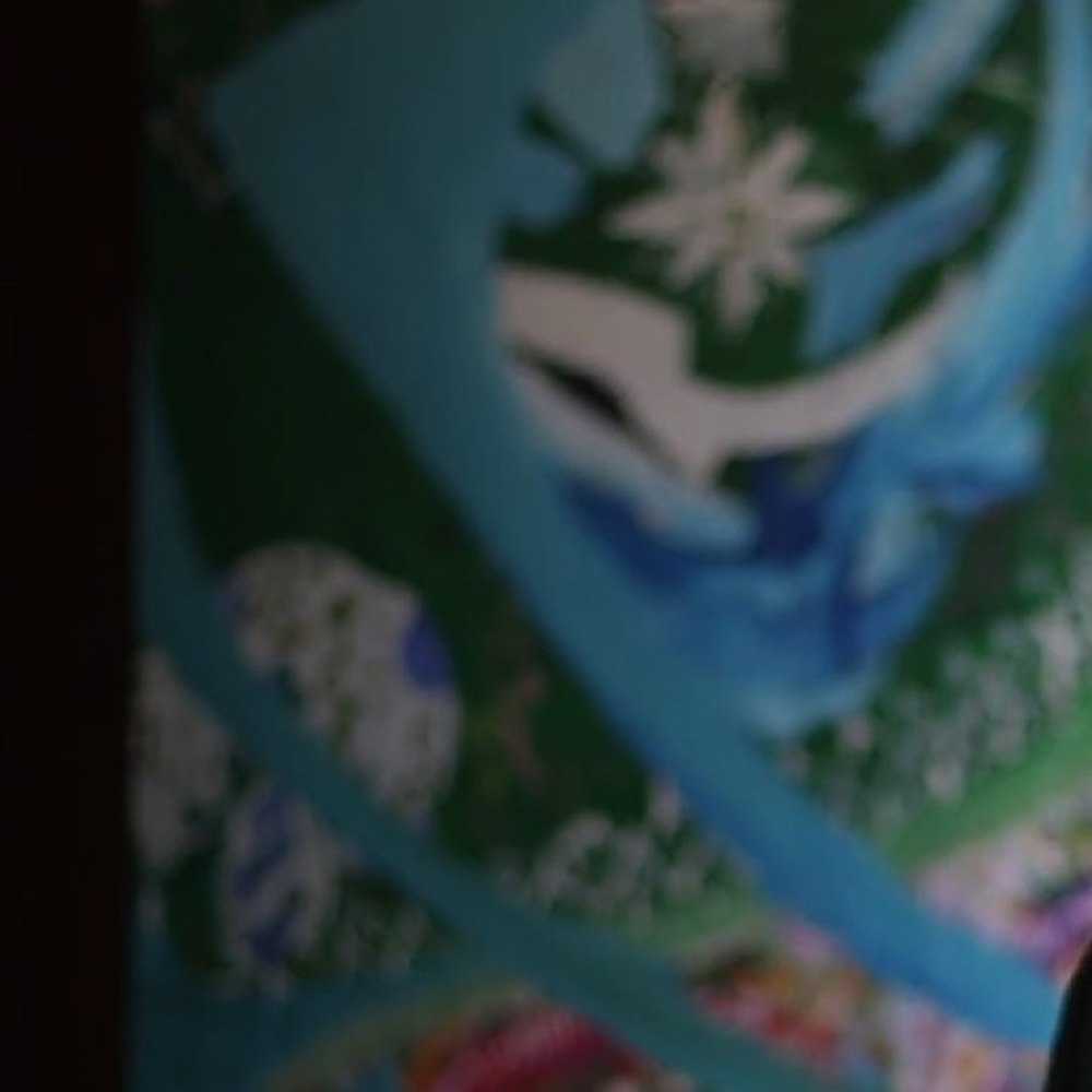 The canvas sits in soft focus behind the artist, a white star on green.